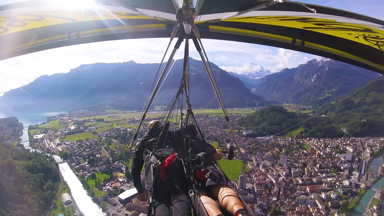 buena toma aérea de gopro pov de un ala delta volando sobre los alpes y pueblos de suiza 4