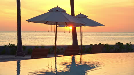 amazing shot of sea view resort with infinity pool and sun umbrellas at sunset