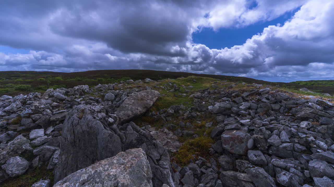 Tidsforløbsvideo af et landligt landskab med neolitisk klippeformation i forgrunden under en forbipasserende regnvejrsdag, set fra Carrowkeel i Sligo County på Irland
