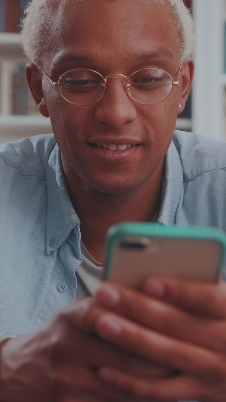 Closeup of a young blonde african american man smiling while browsing on his