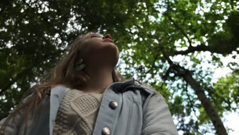 young caucasian female looking up at woodland tree canopy imagination expression concept