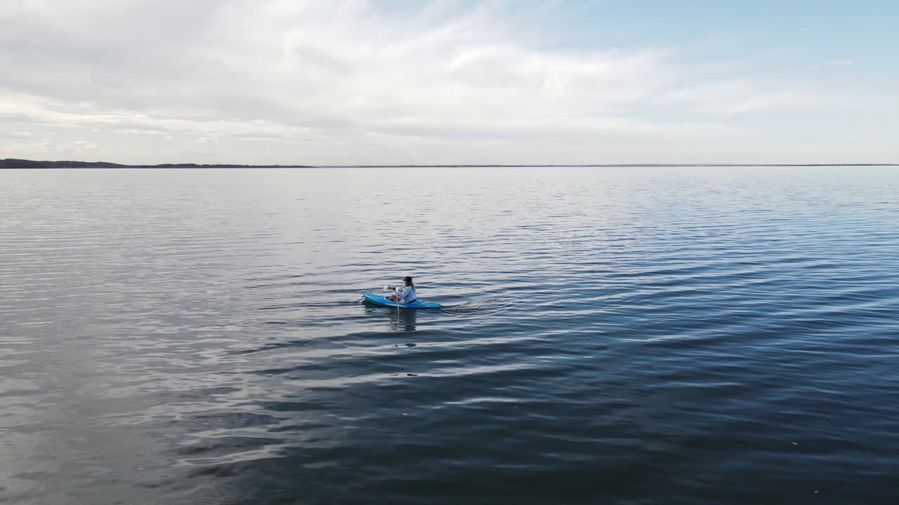 el magnífico agua azul clara del lago buffalo, alberta con una mujer remando en un kayak