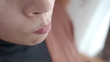 close-up of a woman eating a raisin