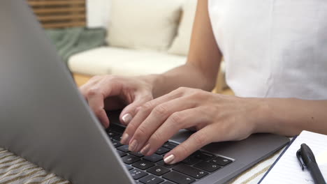 manos femeninas escribiendo correos electrónicos mientras trabaja desde casa en su jardín