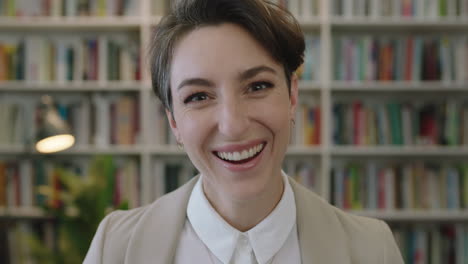 Retrato-De-Una-Joven-Hermosa-Mujer-Caucásica-Riendo-Alegre-Disfrutando-De-Una-Oportunidad-De-Carrera-Mujer-Exitosa-Mirando-La-Cámara-En-El-Fondo-De-La-Estantería-De-La-Biblioteca