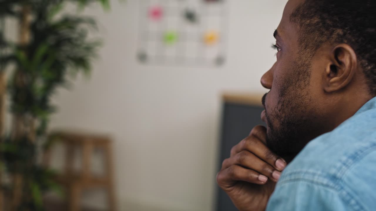 Video of serious black man watching USA election on TV