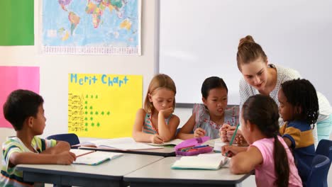 teacher helping kids with their homework in classroom