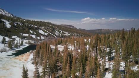 Luftflug-über-Einem-Winterwald-Neben-Einem-Zugefrorenen-See-Im-Mammutsee-Gebirge