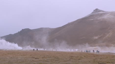 tourists explore the misty geothermal landscape at namaskaro hot springs in iceland