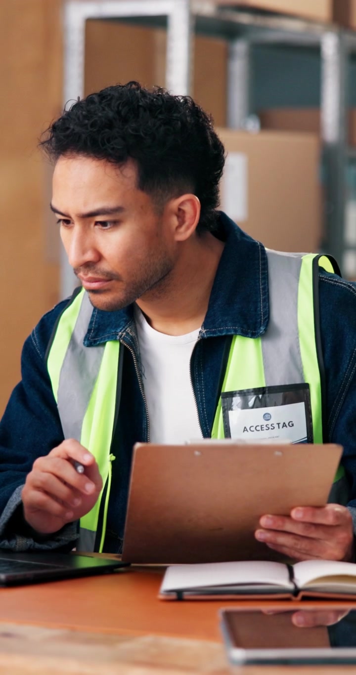 Warehouse Worker Writing on Clipboard in Distribution Center