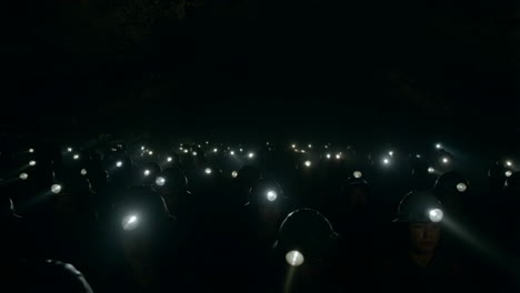 group of miners with headlamps in a dark underground environment