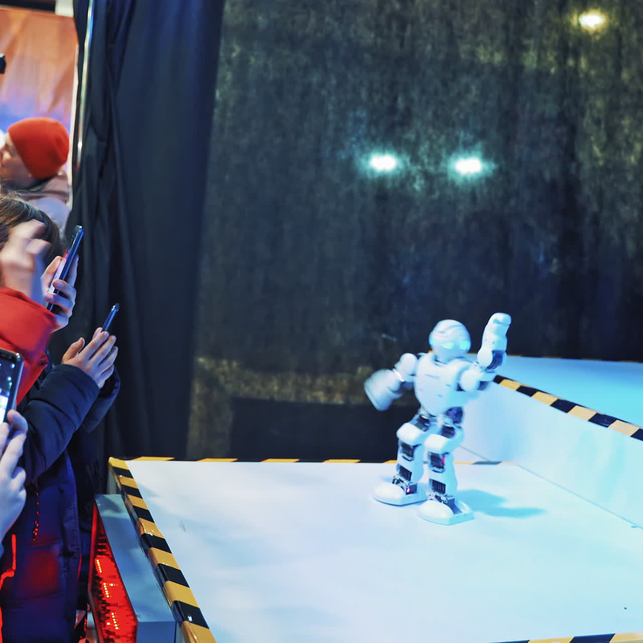 People watch dancing robots at a technology trade show. Robotic dance party. Science Festival