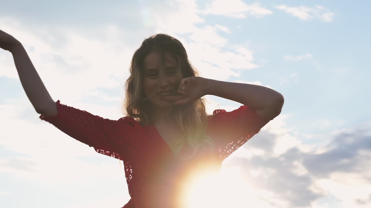 Close up of a smiling woman in bright sunlight, her hair illuminated by the warm glow