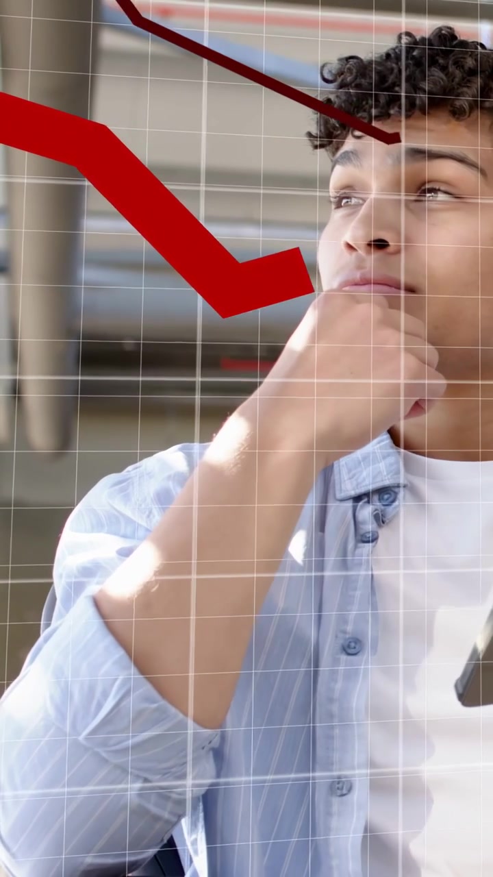 Video verticale: Uomo che tocca un tablet e si tocca il mento, con tendenze rosse e una griglia che mostrano dati finanziari sopra di lui.