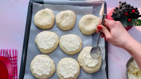 the baker prepares buns with cottage cheese.