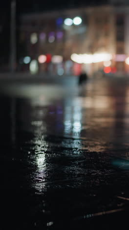 blur view of cars passing with headlights on the road at night, creating vibrant light reflections on the wet pavement