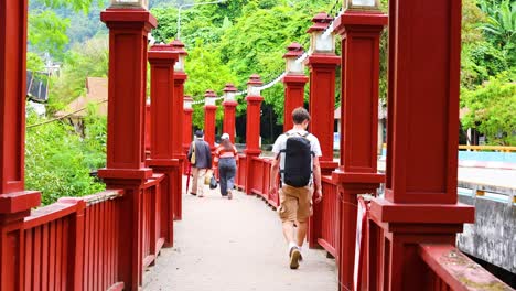 people walking on a vibrant red bridge