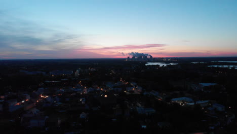 aerial view of a town and power plant at dusk