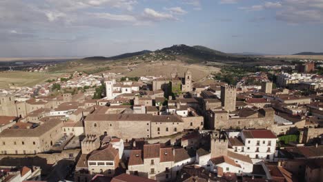 Charming-medieval-city,-vast-countryside-backdrop,-aerial-orbit