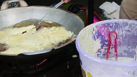 tempe mendoan is fried in hot vegetable oil in a pan