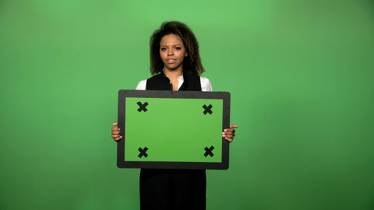 joven hembra sosteniendo una tabla de chromakey
