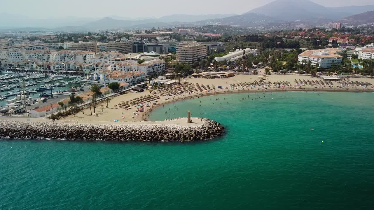 Spiaggia di Puerto Banus a Marbella, vivace porto turistico, coste sabbiose e Mar Mediterraneo, vista aerea.