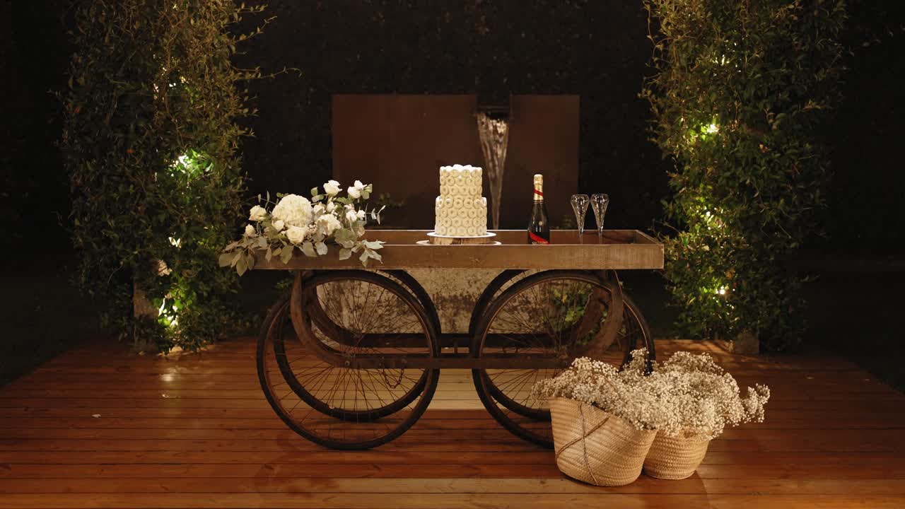 Elegant wedding cake table with floral decor on a rustic bicycle base