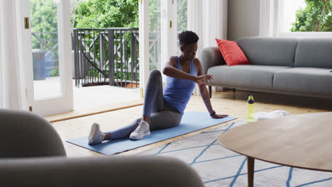 african american woman performing stretching exercise at home