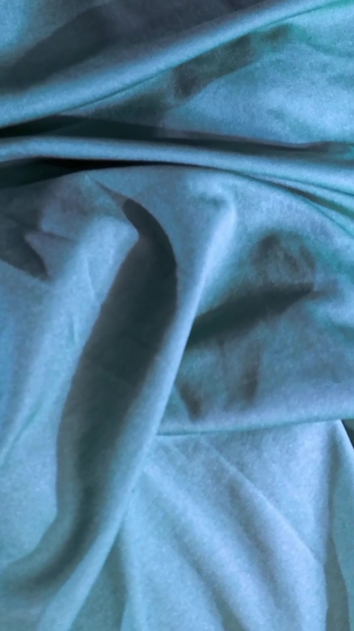 Close-up of Soft Teal Fabric Texture with Gentle Folds