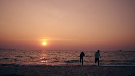 guy-and-girl-go-out-of-sea-water-on-empty-shore-slow-motion