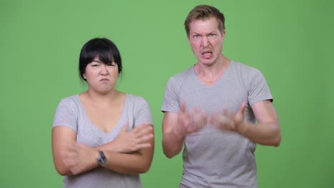 young multi-ethnic couple angrily talking to camera