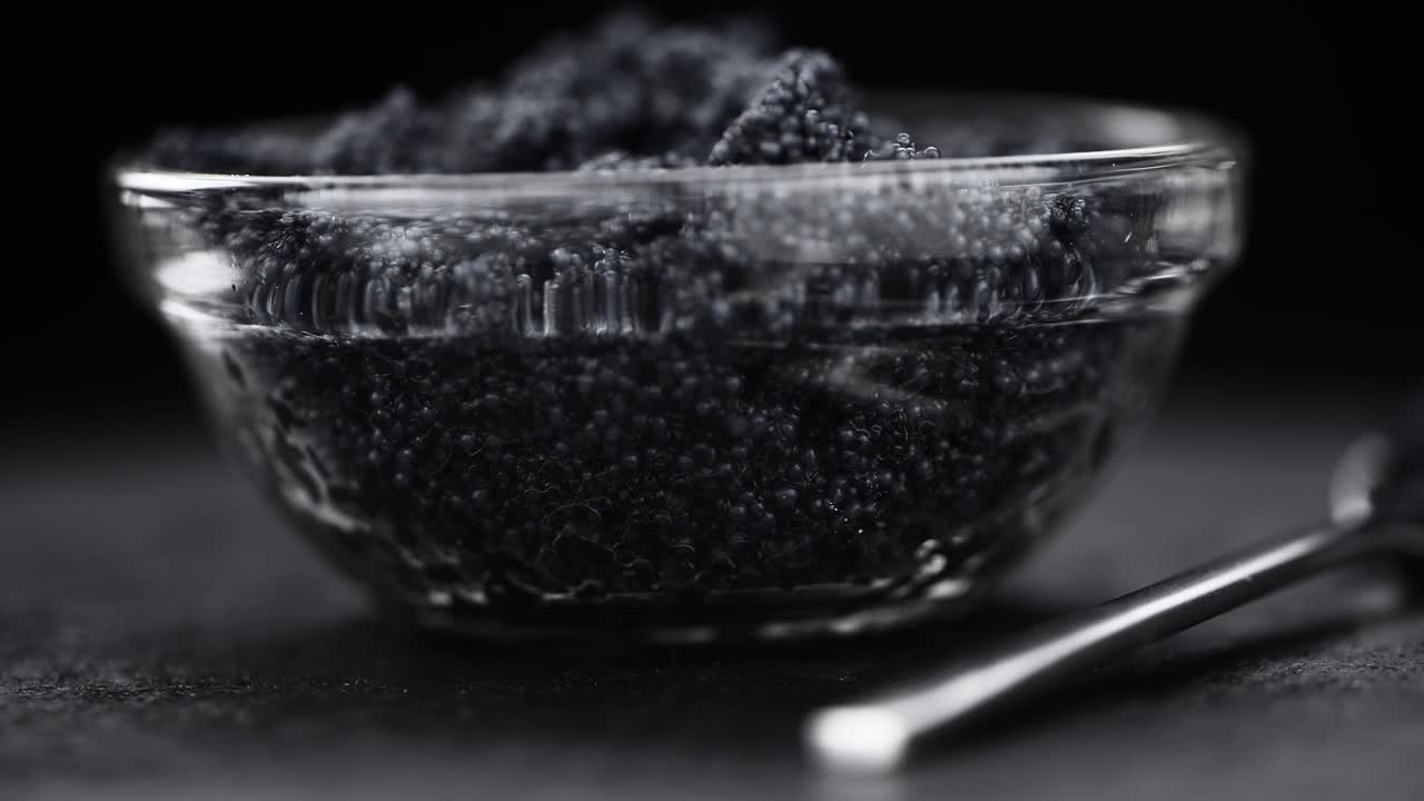 порция черной икры, вращающаяся на тарелке (близко; беспрерывная петля)
