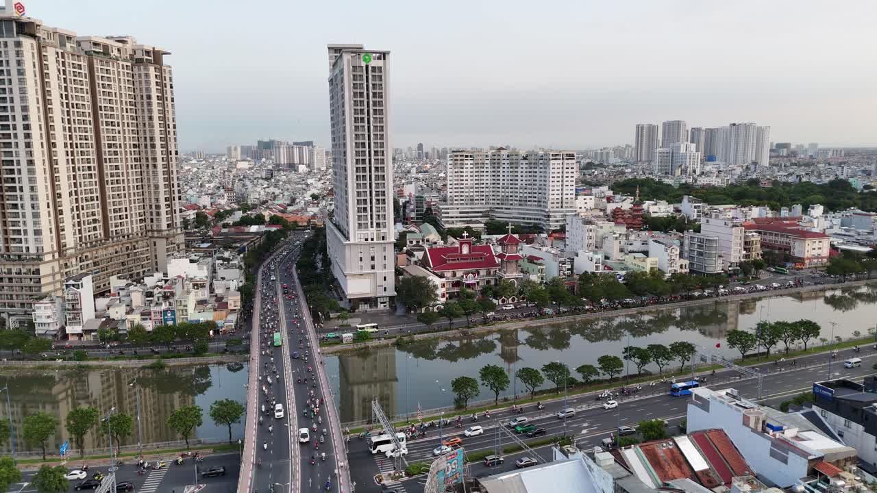 Aerial view of Saigon River gracefully winds through the city, adding a natural element to the urban environment. A dense network of streets pulses with the flow of vehicular traffic and urban life