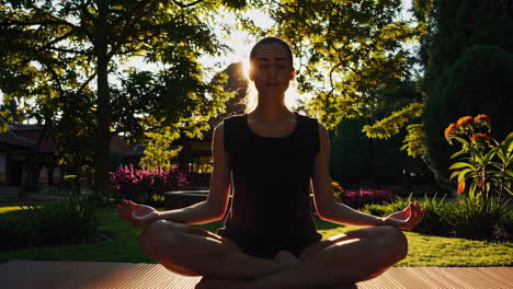 woman meditating in a garden at sunset