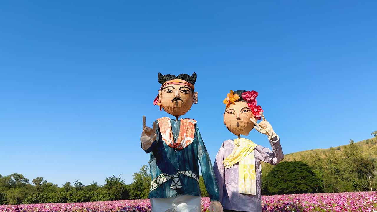 전통 의상 을 입은 두 사람 이 즐겁게 춤 을 추고 있다