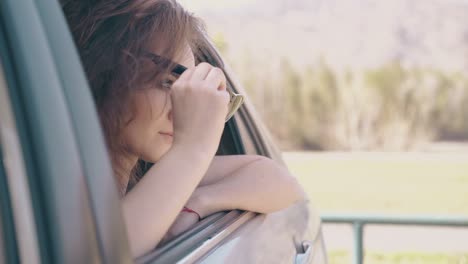 thoughtful woman in sunglasses sits inside modern car