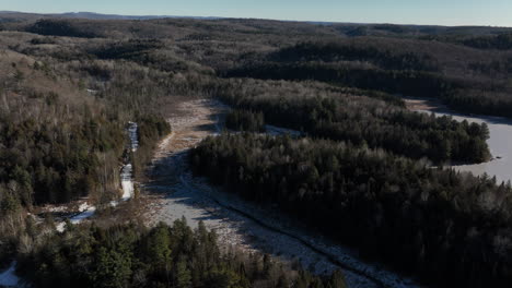 Panoramic-View-Of-Dense-Forest-With-Frozen-Lake-During-Winter-In-Canada