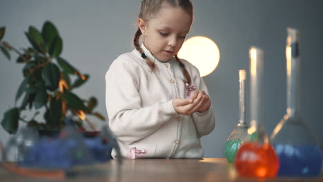 kleines mädchen spielt mit laborglas. kind und wissenschaft.