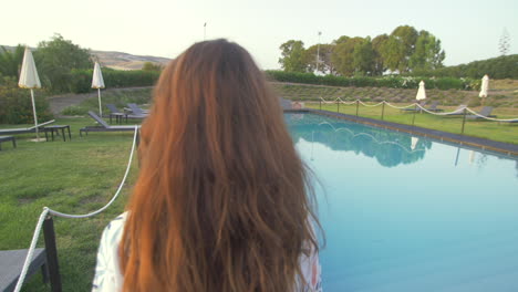 woman walking by the pool on a summer day