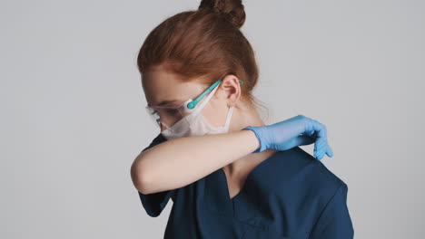 redheaded doctor in front of camera on gray background.