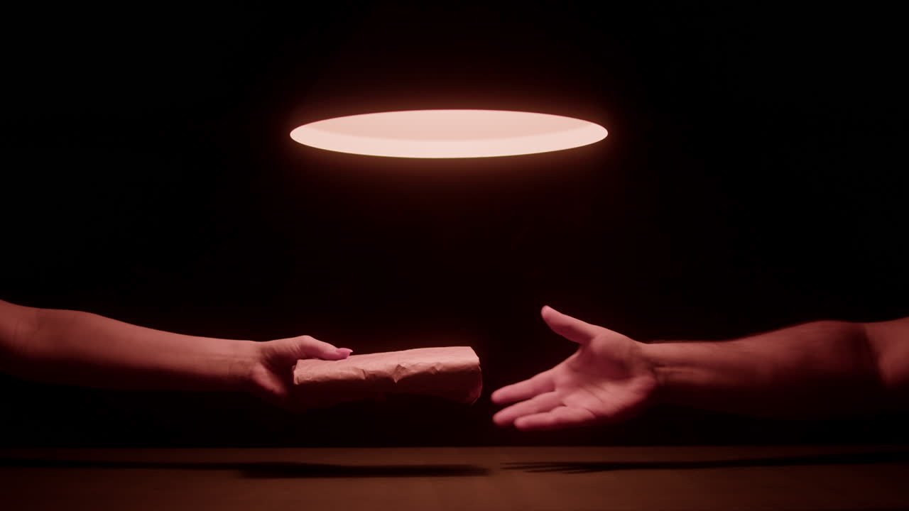 Illicit Package Transaction Between Two Hands in a Dark Room