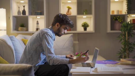 unhappy man using laptop laptop at night. it's not in a good mood.