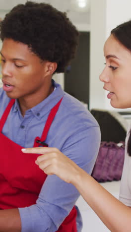 video de una mujer propietaria y un camarero trabajando con una computadora portátil en una cafetería