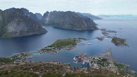 La-Gente-Disfruta-De-La-Vista-En-La-Caminata-Reinebringen-En-Reine,-Archipiélago-De-Las-Islas-Lofoten,-Noruega---Círculos-Aéreos-4k