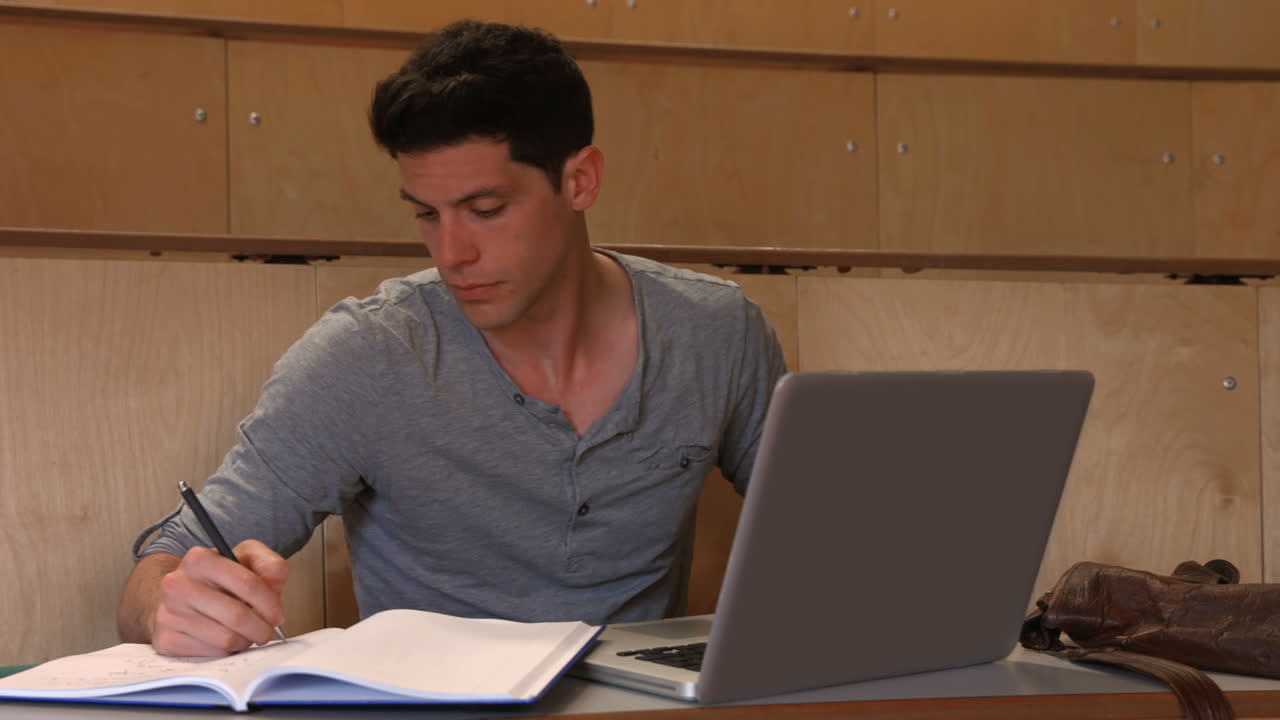 estudiante tomando notas en la conferencia