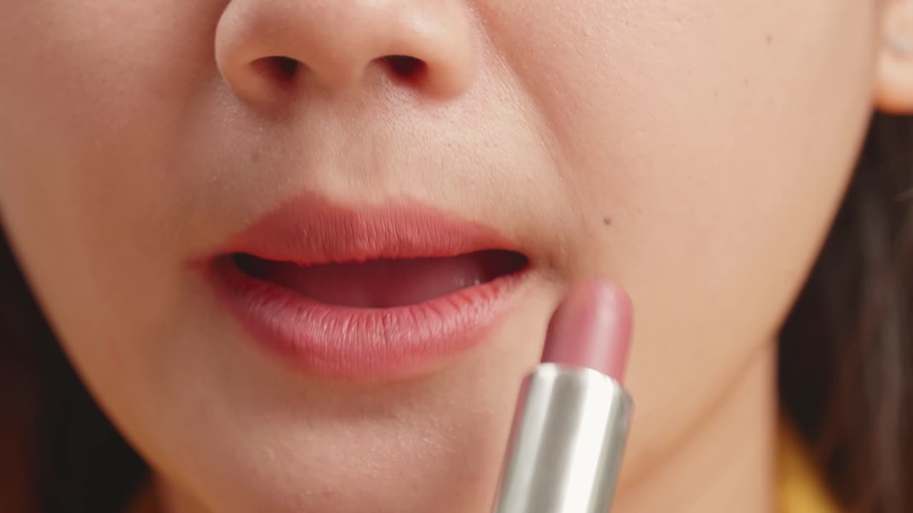 mujer aplicando lápiz labial