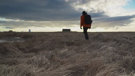 el hombre camina en el prado en un día ventoso bajo un cielo nublado en selfoss, islandia