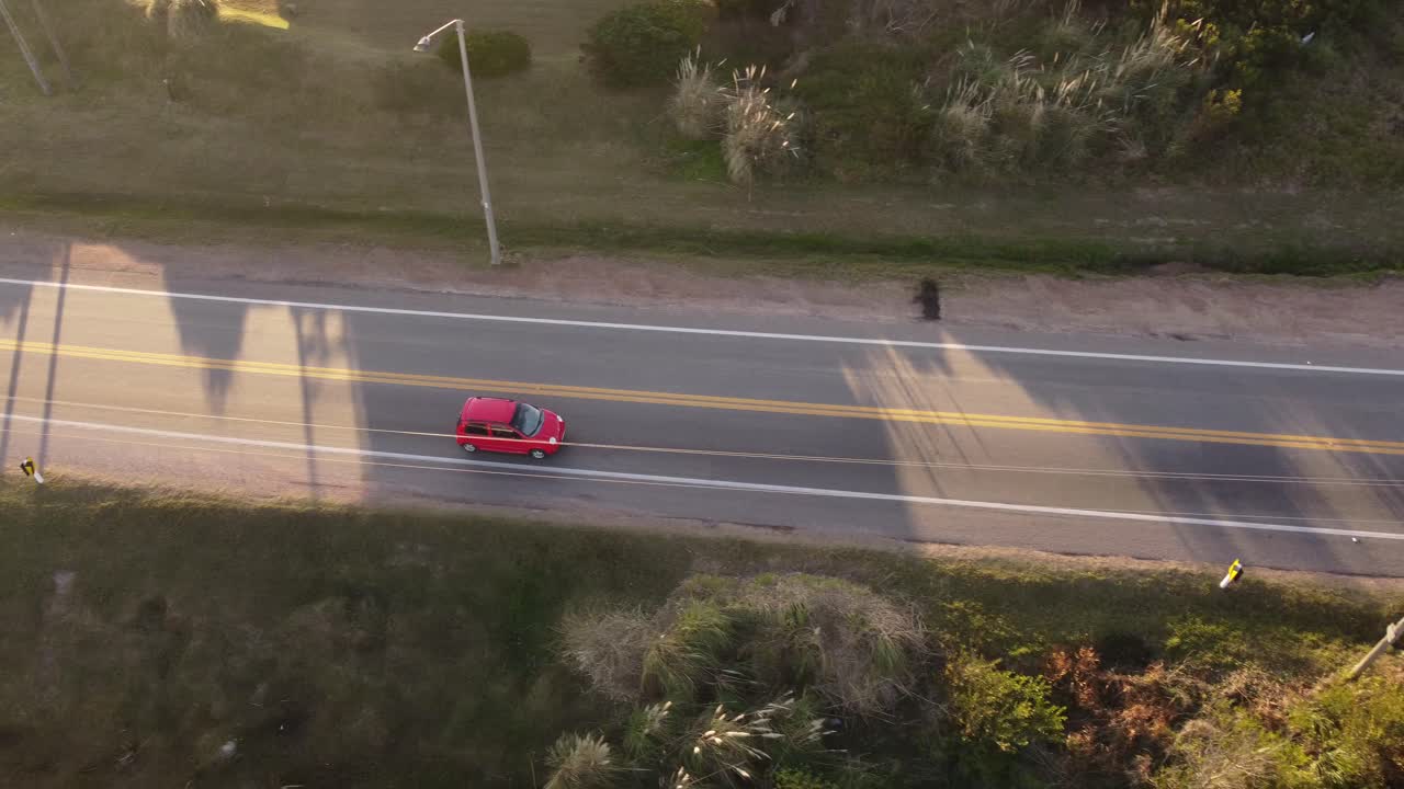 Carro vermelho dirigindo na rodovia de Punta del Este, Uruguai.