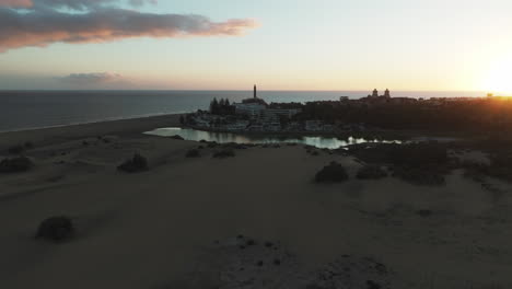 Aerial-view-in-orbit-during-the-sunset-of-the-dunes-of-Maspalomas-and-the-pond-found-in-this-natural-area