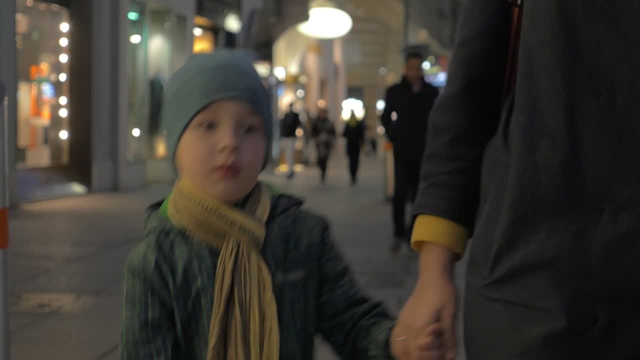 저녁 도시 거리에서 어머니와 함께 고 있는 아이